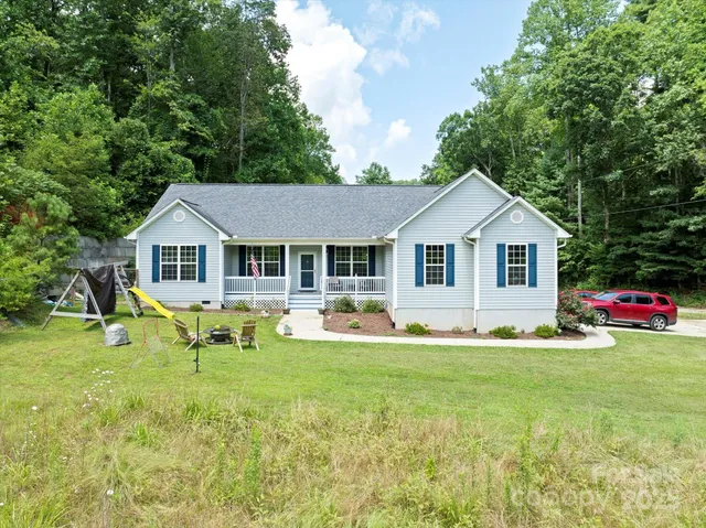 a front view of a house with a yard and trees