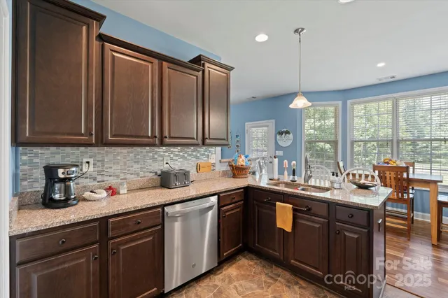 a kitchen with granite countertop a sink stainless steel appliances and cabinets
