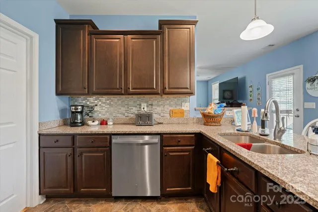 a kitchen with stainless steel appliances granite countertop a sink refrigerator and microwave