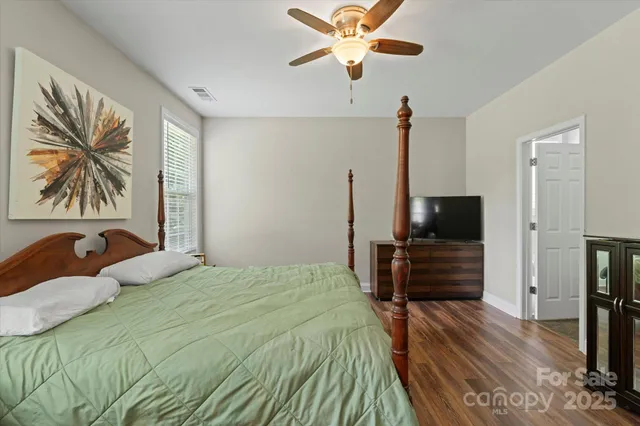a bed sitting in a spacious bedroom next to a window