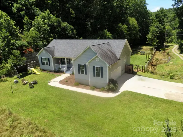 a view of a house with pool and a yard