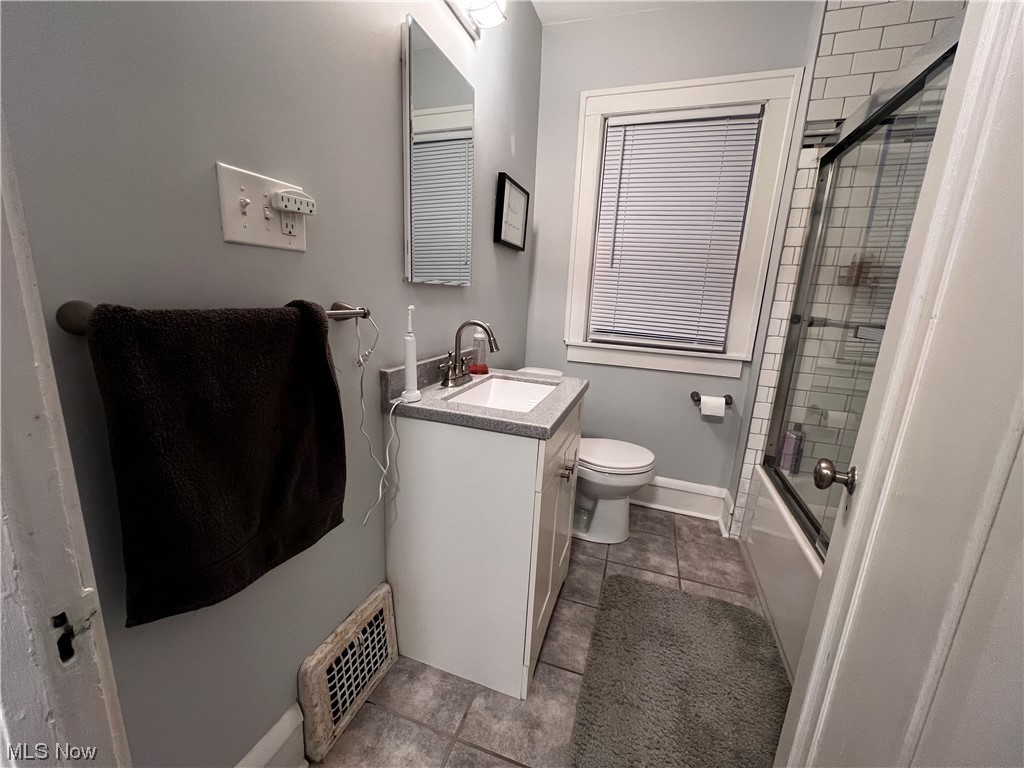 17108 Kenyon Road Cleveland, OH 44120 - Photo 13 of 35 Full bathroom featuring bath / shower combo with glass door, vanity, toilet, and tile floors