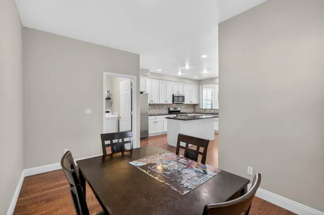 a kitchen with stainless steel appliances granite countertop white cabinets and a stove a oven with white countertops
