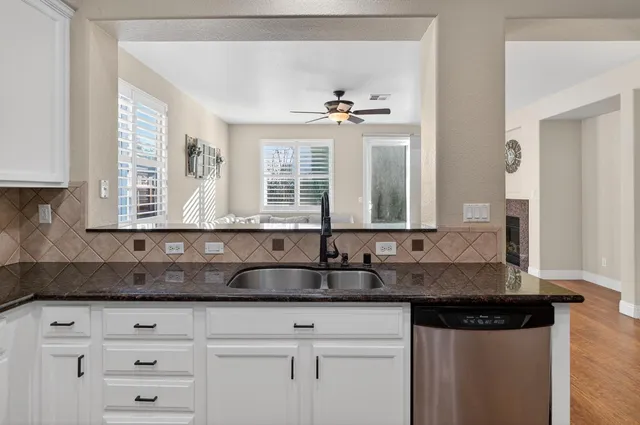 a view of a hallway with a livingroom and bathroom with sink
