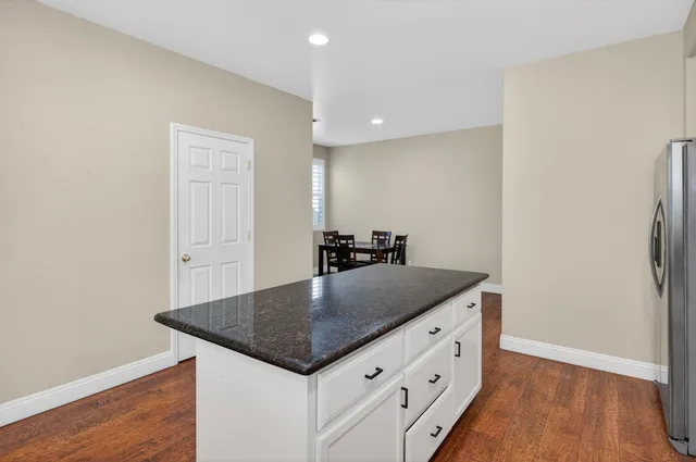 a bathroom with a granite countertop sink a toilet and a mirror
