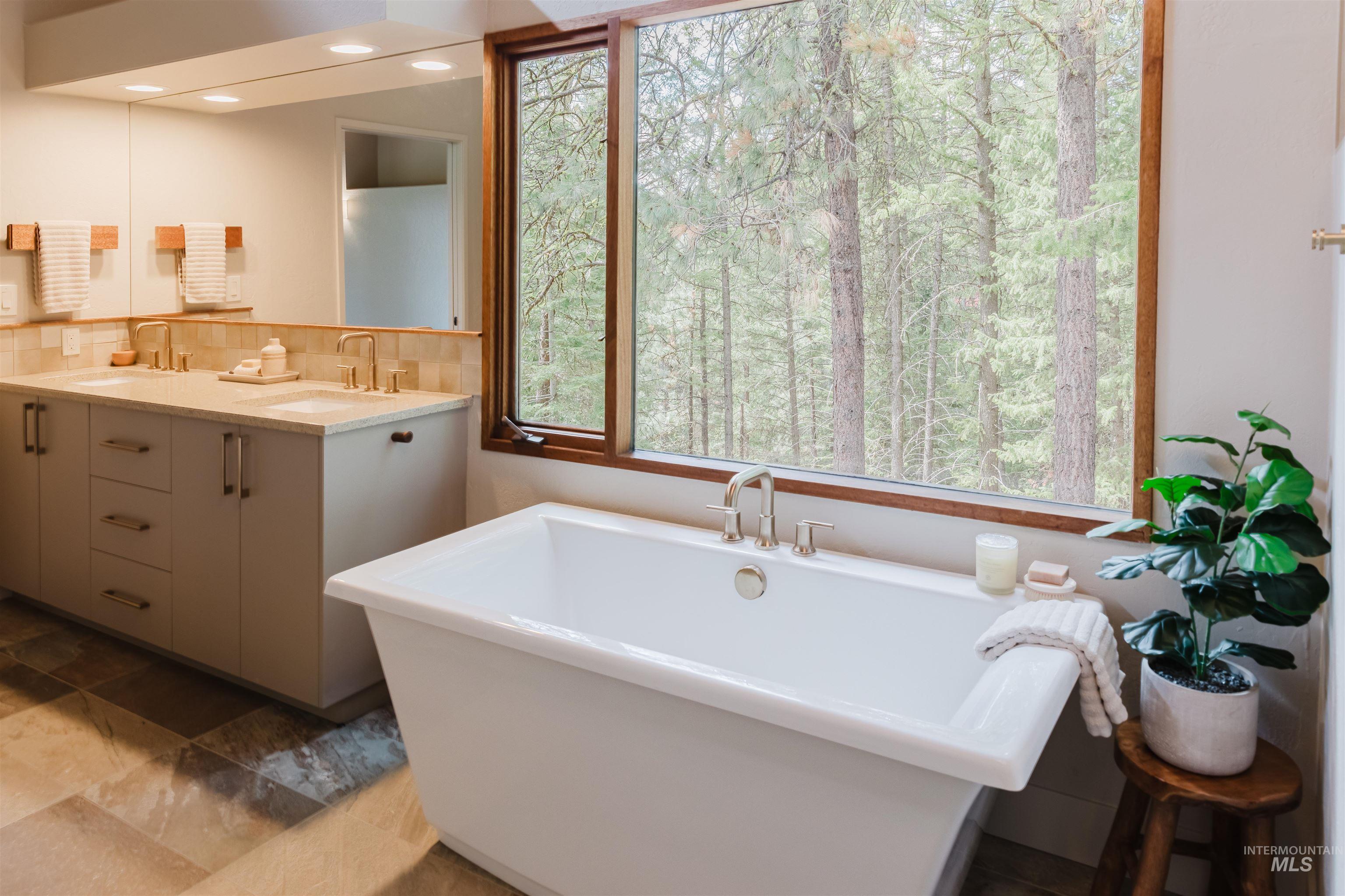 136 Silver Fox Trail McCall, ID 83638 - Photo 16 of 29 Soaking tub positioned before a large window with a wood frame