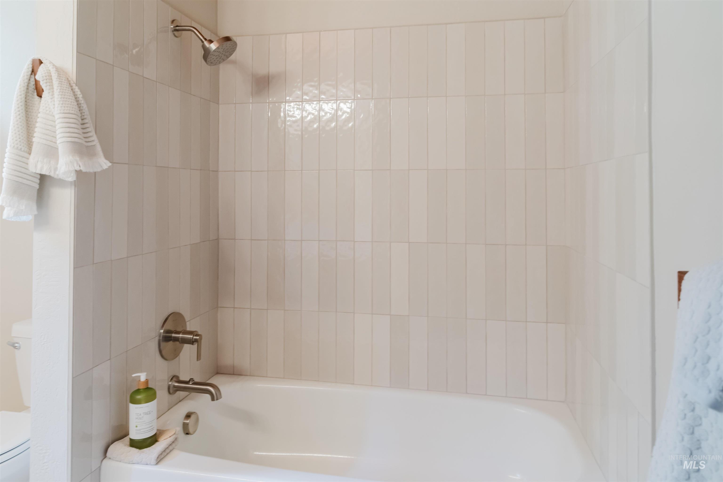 136 Silver Fox Trail McCall, ID 83638 - Photo 19 of 29 Bathtub and shower combination featuring floor-to-ceiling vertical tilework
