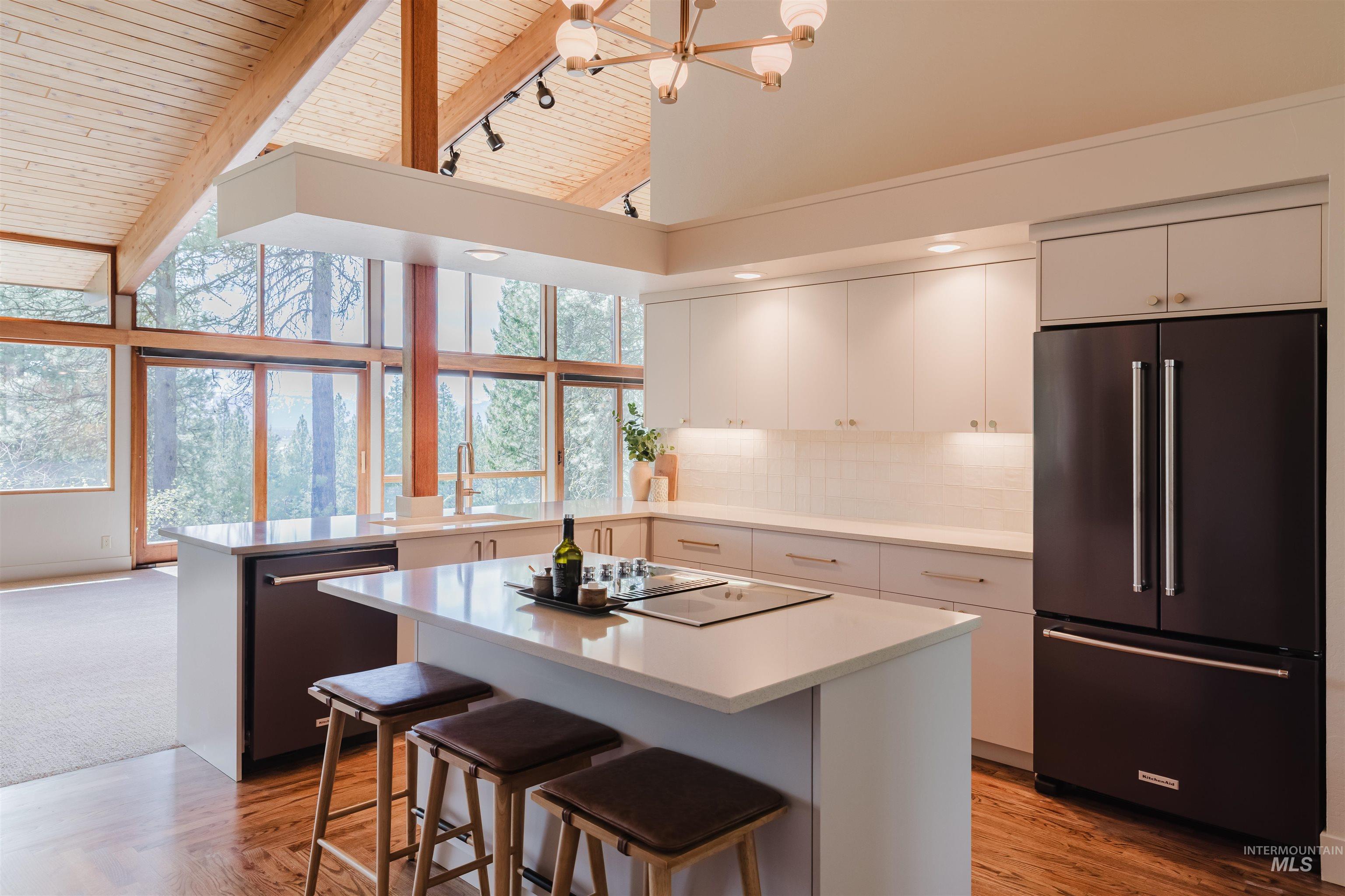 136 Silver Fox Trail McCall, ID 83638 - Photo 6 of 29 Modern kitchen featuring a central island with a built-in cooktop, light-toned cabinetry, and stainless steel appliances