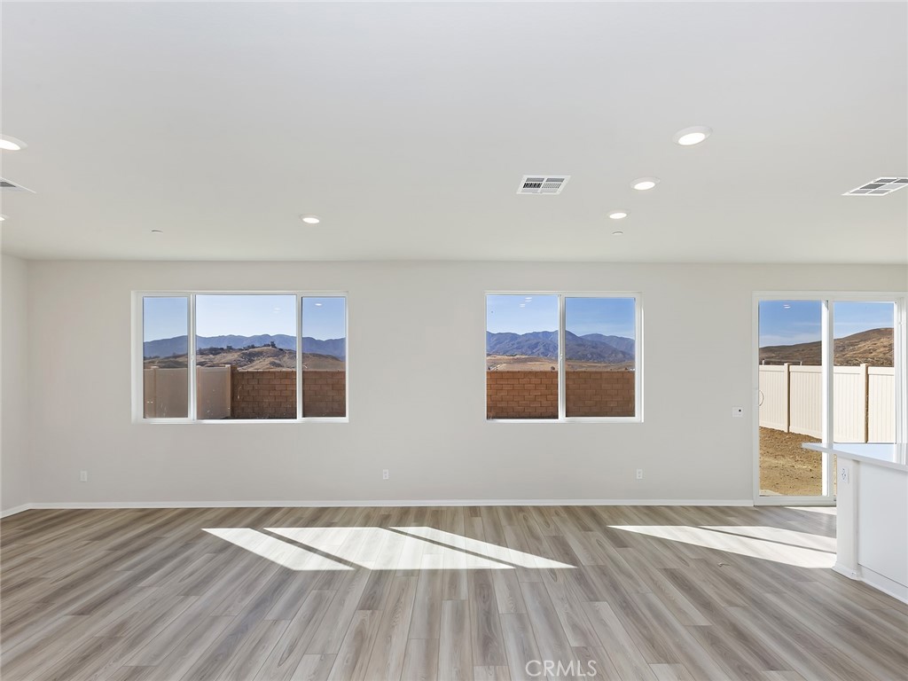 19557 Hanging Rock Road Lake Elsinore, CA 92532 - Photo 13 of 54 a view of an empty room with wooden floor and a window