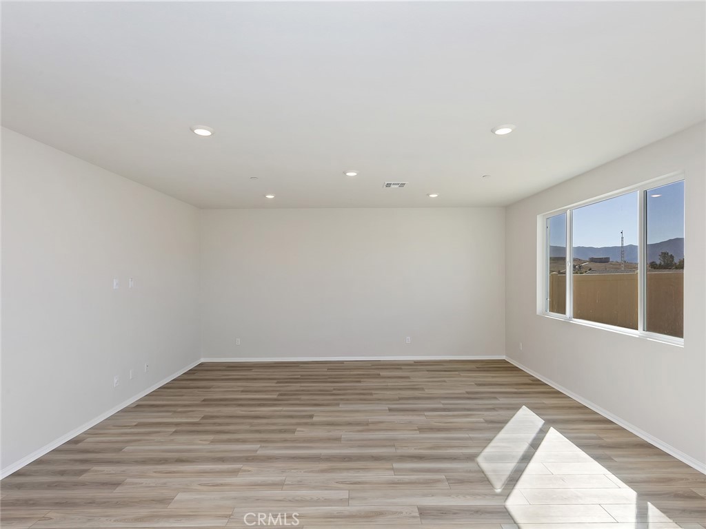 19557 Hanging Rock Road Lake Elsinore, CA 92532 - Photo 14 of 54 an empty room with wooden floor and windows