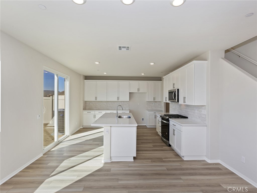 19557 Hanging Rock Road Lake Elsinore, CA 92532 - Photo 17 of 54 a kitchen with stainless steel appliances refrigerator oven and cabinets