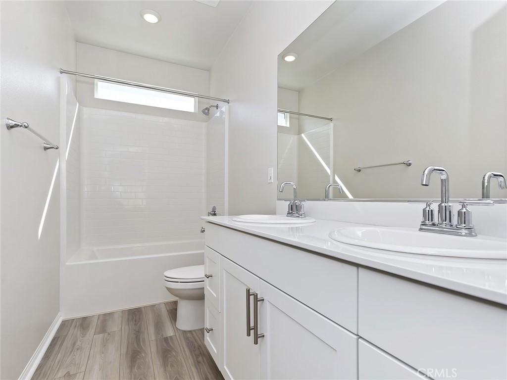 19557 Hanging Rock Road Lake Elsinore, CA 92532 - Photo 31 of 54 a bathroom with a sink a toilet and a large mirror