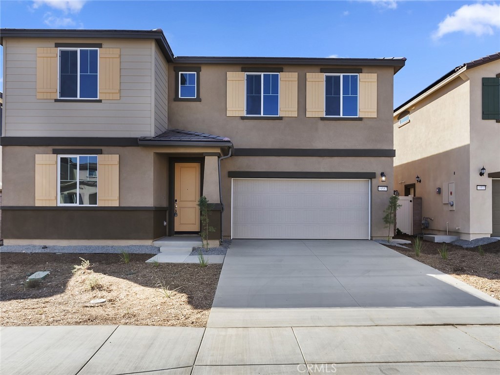 19557 Hanging Rock Road Lake Elsinore, CA 92532 - Photo 4 of 54 a front view of a house with a yard and garage