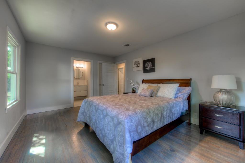 2011 Fort View Road Austin, TX 78704 - Photo 20 of 28 Gleaming hardwood floors and a private en suite bathroom highlight this serene primary bedroom.
