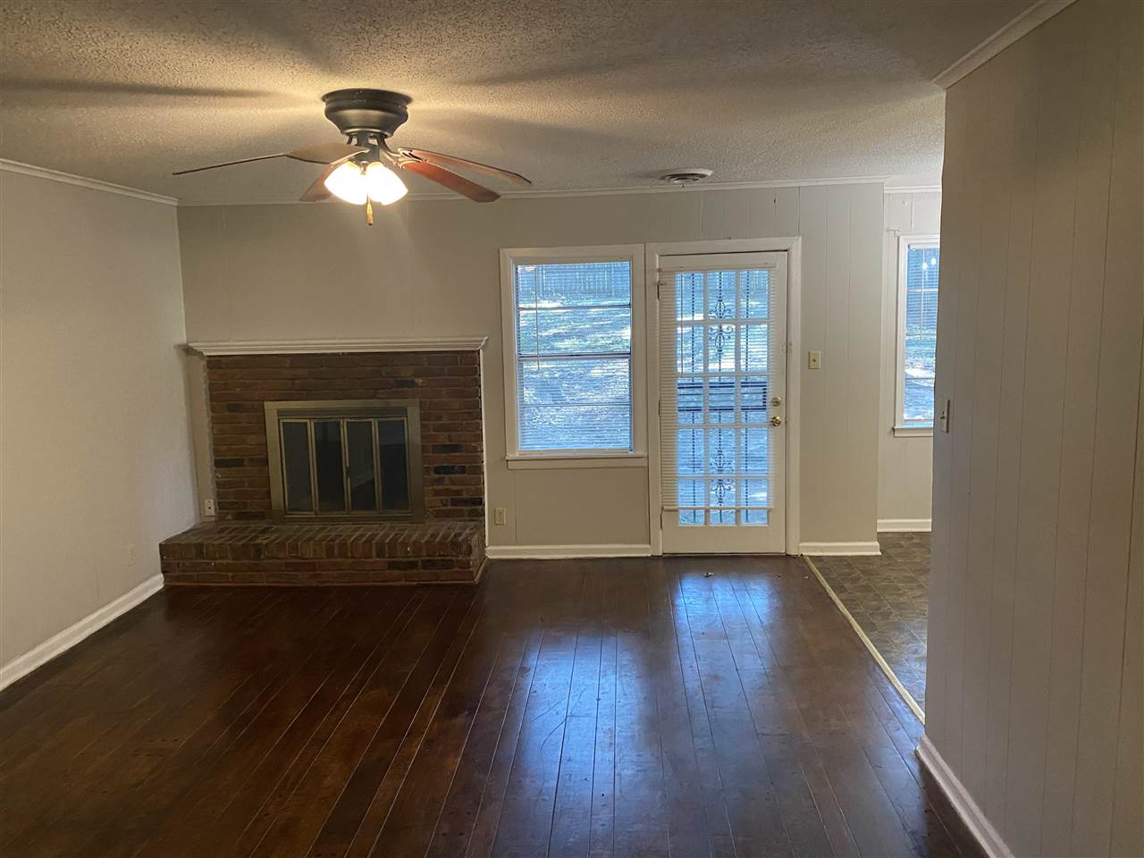 4066 Bishops Bridge Road Memphis, TN 38118 - Photo 9 of 19 a view of an empty room with wooden floor fireplace and a window