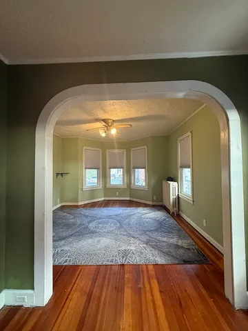 a view of empty room with wooden floor