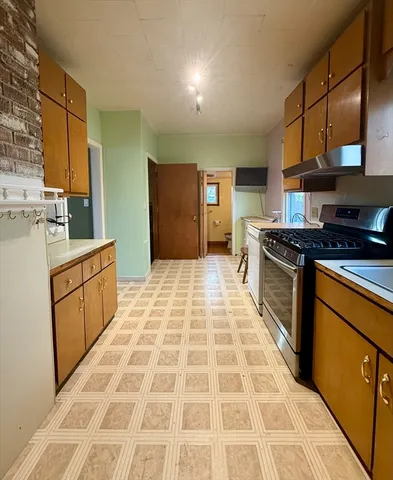 a kitchen with stainless steel appliances granite countertop a stove a sink and a microwave