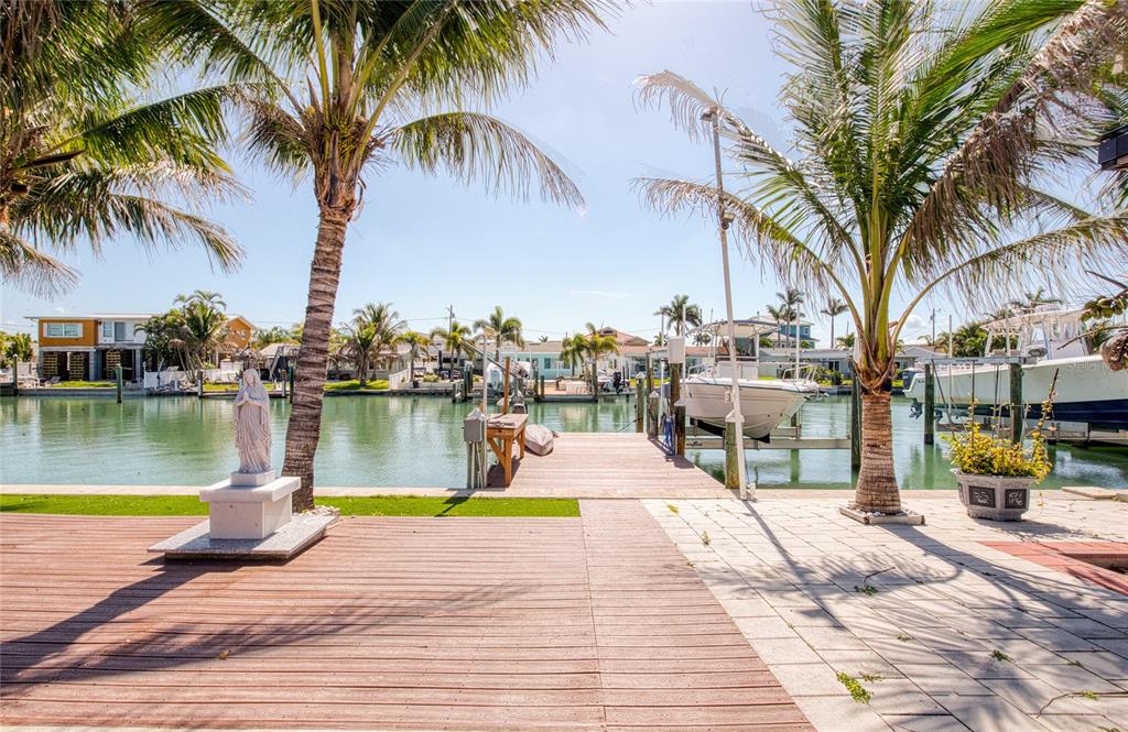 551 Crystal Drive Madeira Beach, FL 33708 - Photo 14 of 46 a view of a swimming pool with a chair and palm trees
