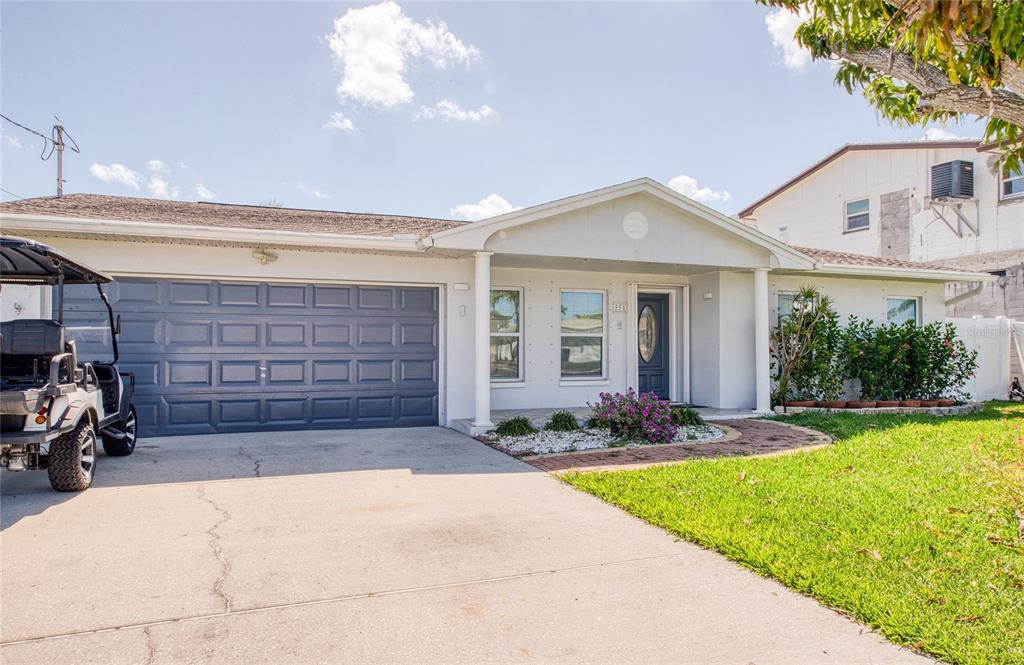 551 Crystal Drive Madeira Beach, FL 33708 - Photo 2 of 46 a front view of a house with a yard and garage