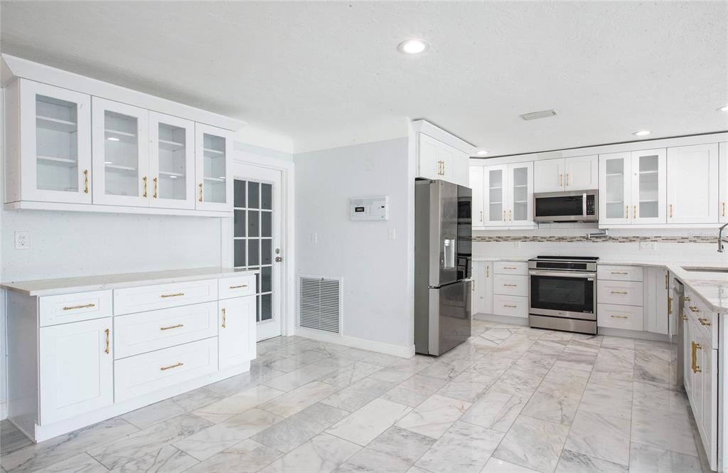 551 Crystal Drive Madeira Beach, FL 33708 - Photo 23 of 46 a kitchen with cabinets stainless steel appliances and a window
