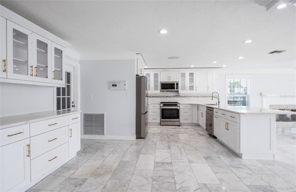 551 Crystal Drive Madeira Beach, FL 33708 - Photo 24 of 46 a large white kitchen with cabinets and stainless steel appliances