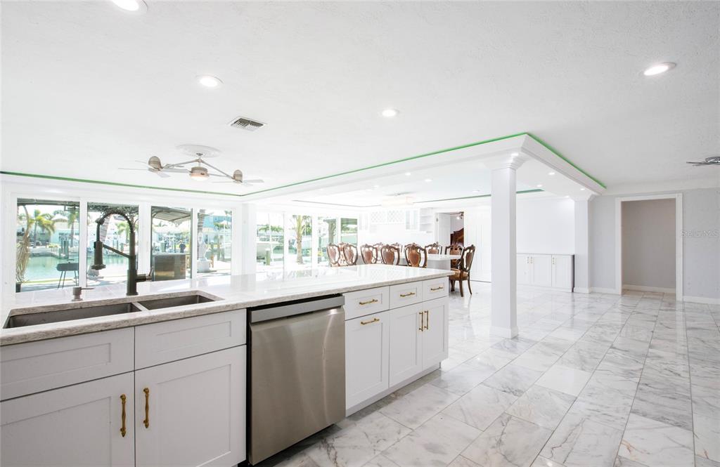 551 Crystal Drive Madeira Beach, FL 33708 - Photo 27 of 46 a kitchen with granite countertop a sink and white cabinets