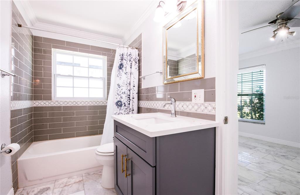 551 Crystal Drive Madeira Beach, FL 33708 - Photo 35 of 46 a bathroom with a sink a toilet a tub and window