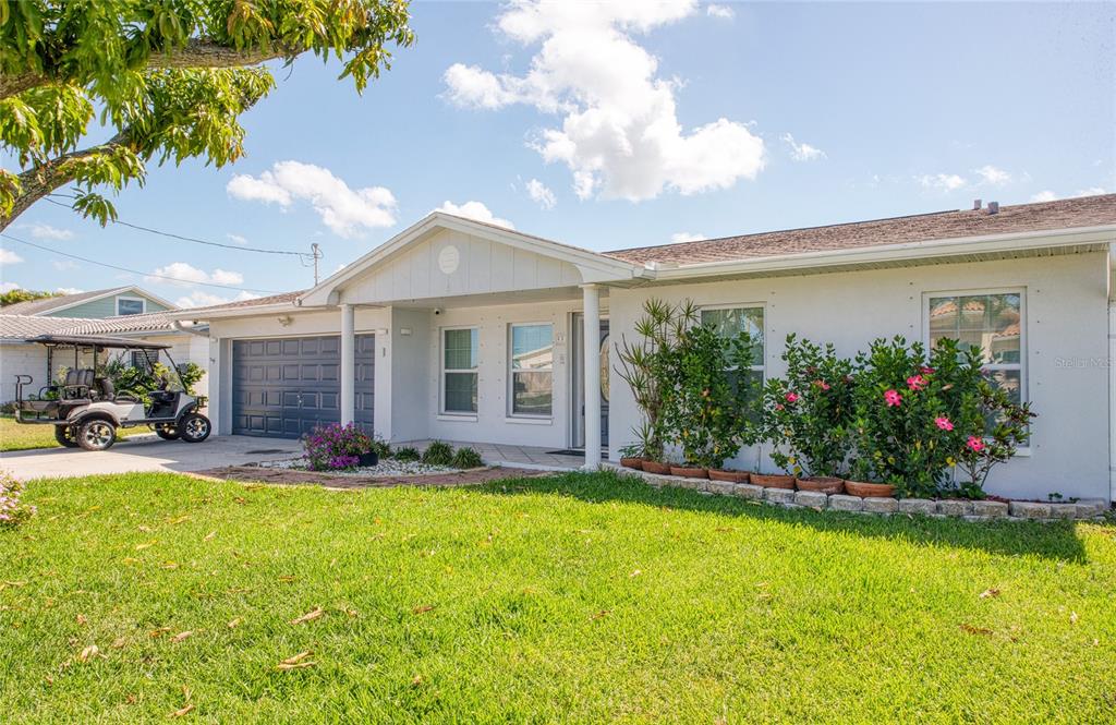 551 Crystal Drive Madeira Beach, FL 33708 - Photo 4 of 46 a view of a house with a big yard and potted plants