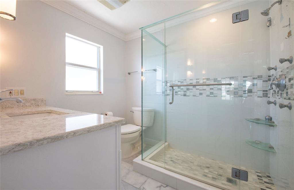 551 Crystal Drive Madeira Beach, FL 33708 - Photo 42 of 46 a bathroom with a granite countertop sink a toilet and shower