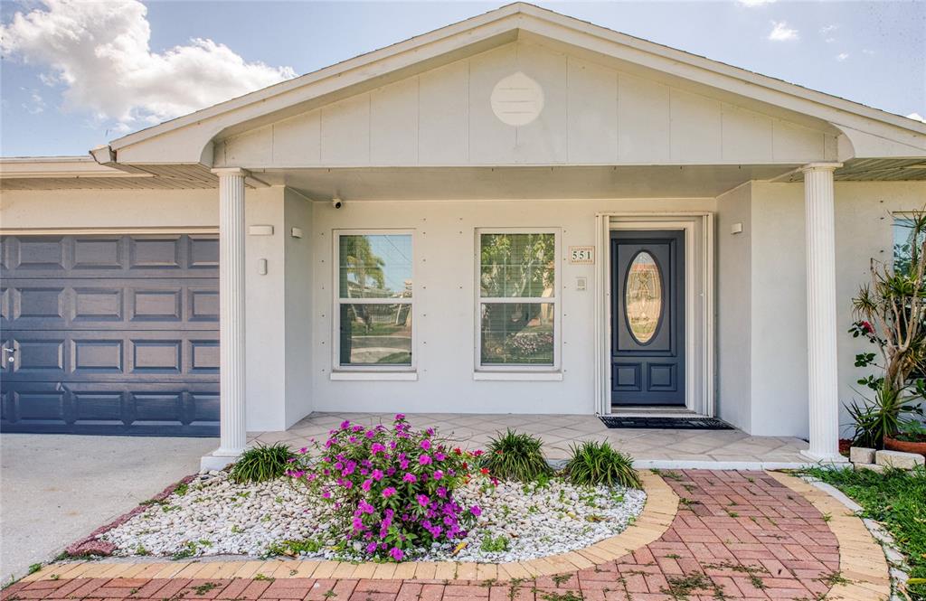 551 Crystal Drive Madeira Beach, FL 33708 - Photo 5 of 46 a front view of a house with a porch