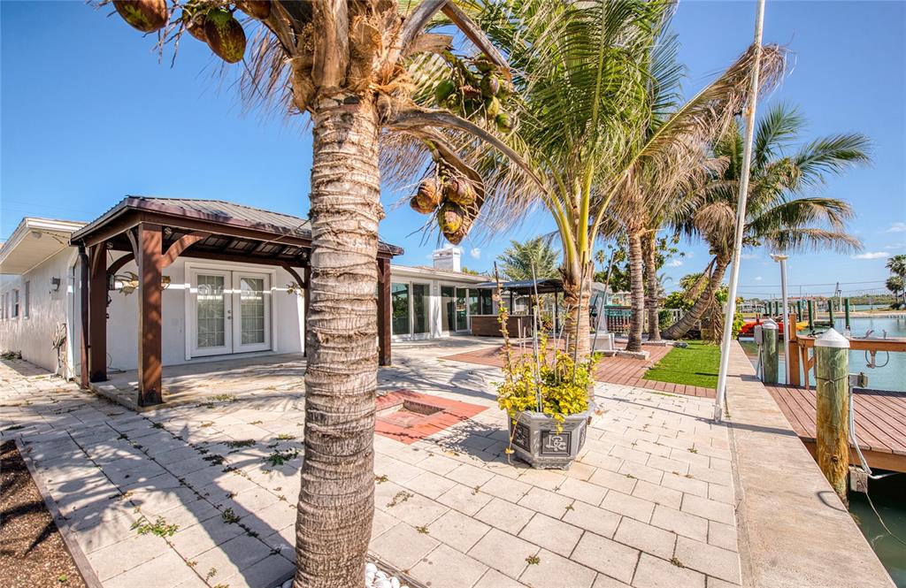 551 Crystal Drive Madeira Beach, FL 33708 - Photo 6 of 46 a view of a house with a large tree and a yard