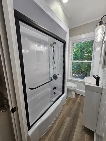 a bathroom with a glass shower door and a window