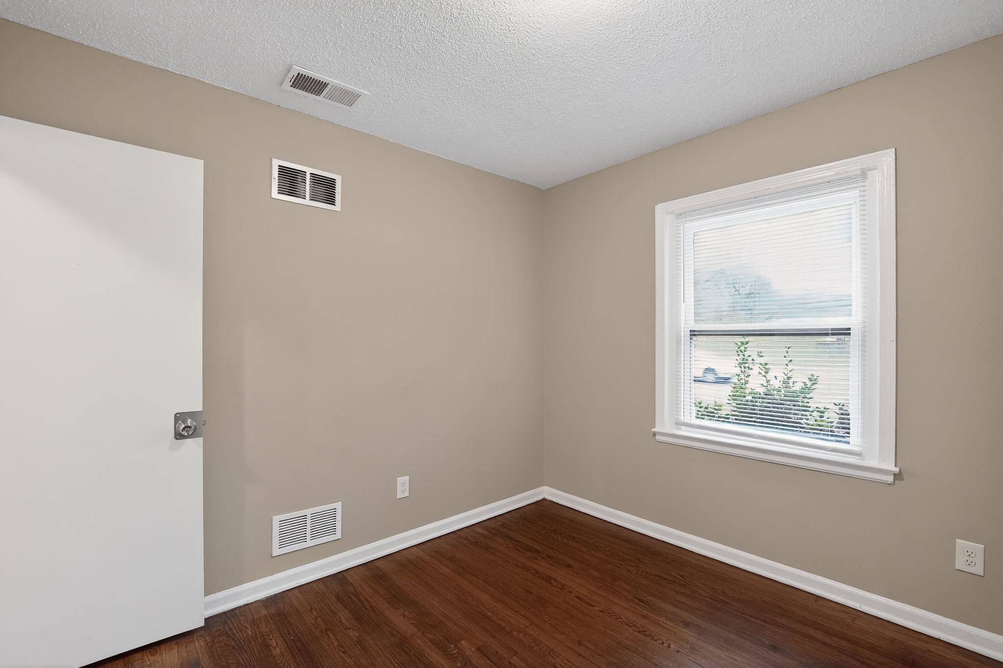 4689 Raleigh Lagrange Road Memphis, TN 38128 - Photo 11 of 30 Unfurnished room featuring a textured ceiling and dark wood-style flooring