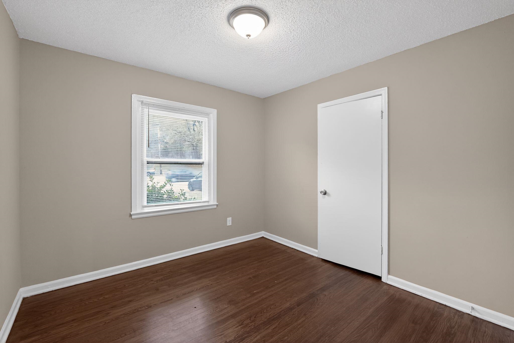 4689 Raleigh Lagrange Road Memphis, TN 38128 - Photo 13 of 30 Unfurnished room featuring dark wood-type flooring and a textured ceiling