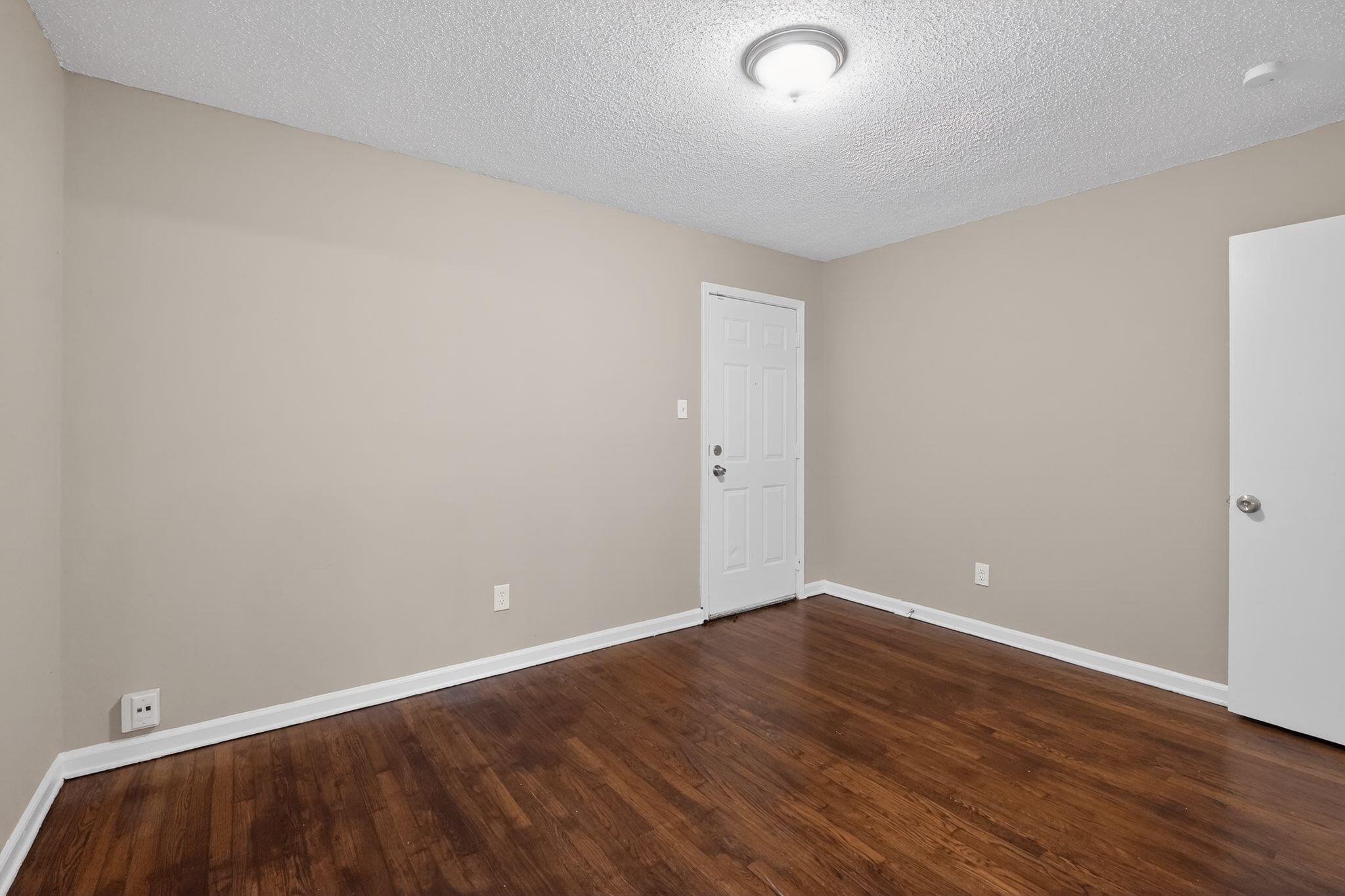 4689 Raleigh Lagrange Road Memphis, TN 38128 - Photo 14 of 30 Spare room featuring a textured ceiling and dark wood finished floors