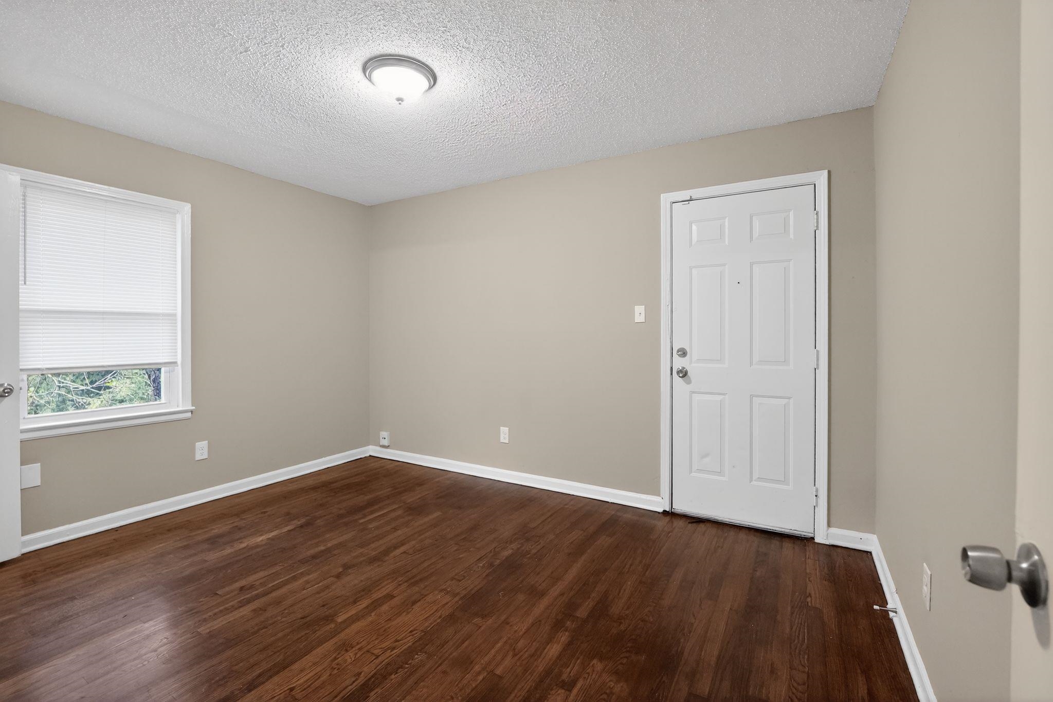 4689 Raleigh Lagrange Road Memphis, TN 38128 - Photo 16 of 30 Spare room featuring dark wood-style floors and a textured ceiling