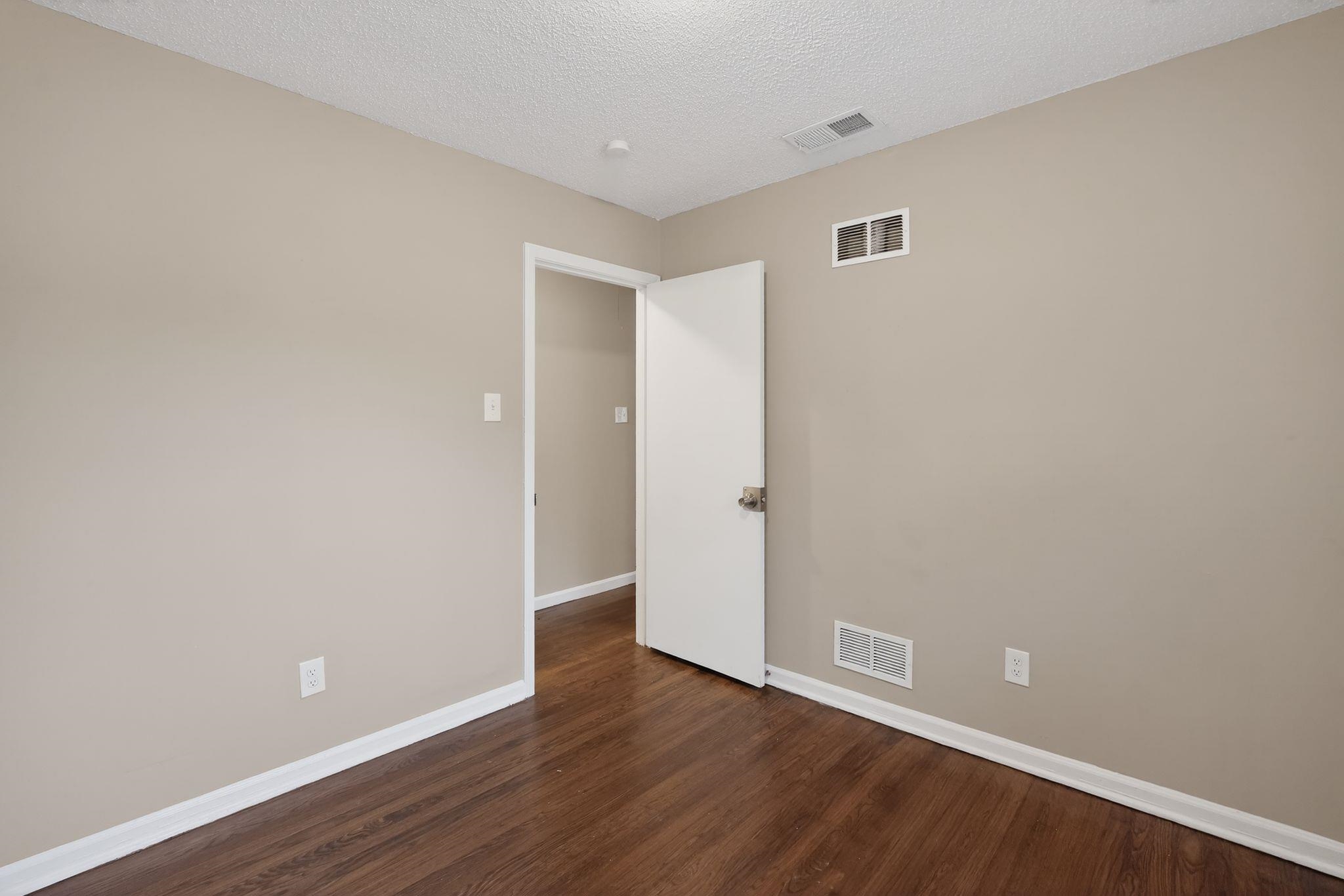 4689 Raleigh Lagrange Road Memphis, TN 38128 - Photo 19 of 30 Spare room featuring a textured ceiling and dark wood-style floors