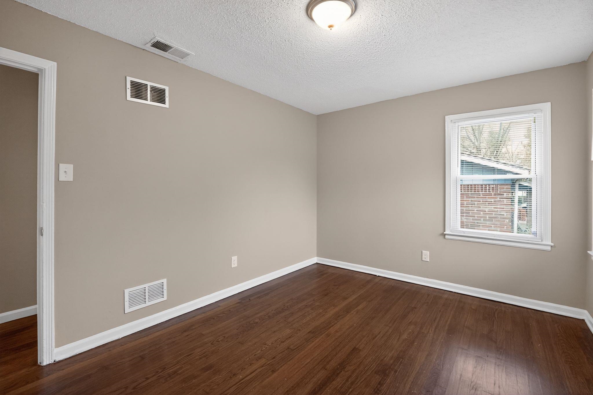 4689 Raleigh Lagrange Road Memphis, TN 38128 - Photo 20 of 30 Empty room with dark wood finished floors and a textured ceiling