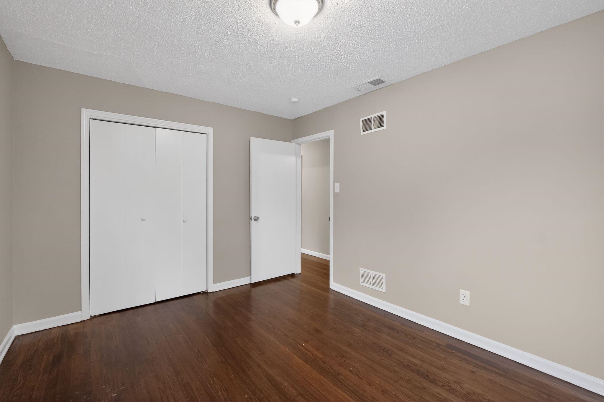 4689 Raleigh Lagrange Road Memphis, TN 38128 - Photo 21 of 30 Unfurnished bedroom with a closet, a textured ceiling, and dark wood-style floors