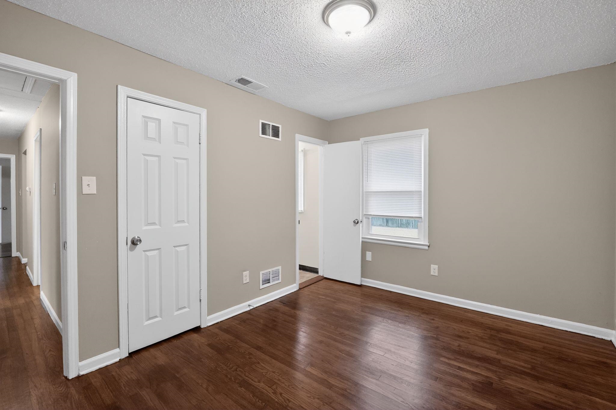 4689 Raleigh Lagrange Road Memphis, TN 38128 - Photo 22 of 30 Unfurnished bedroom with dark wood finished floors and a textured ceiling