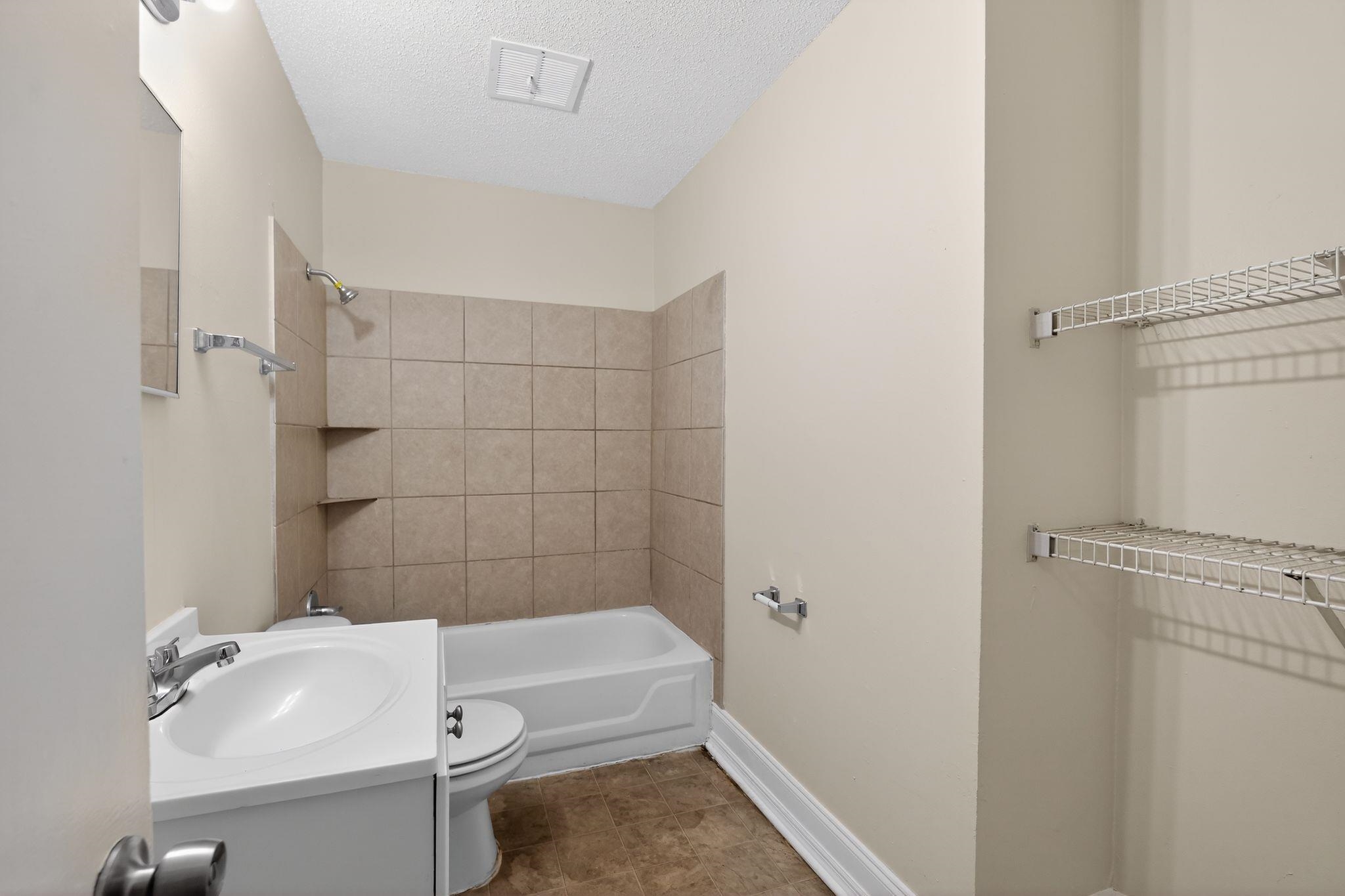 4689 Raleigh Lagrange Road Memphis, TN 38128 - Photo 26 of 30 Bathroom featuring a textured ceiling, washtub / shower combination, and vanity