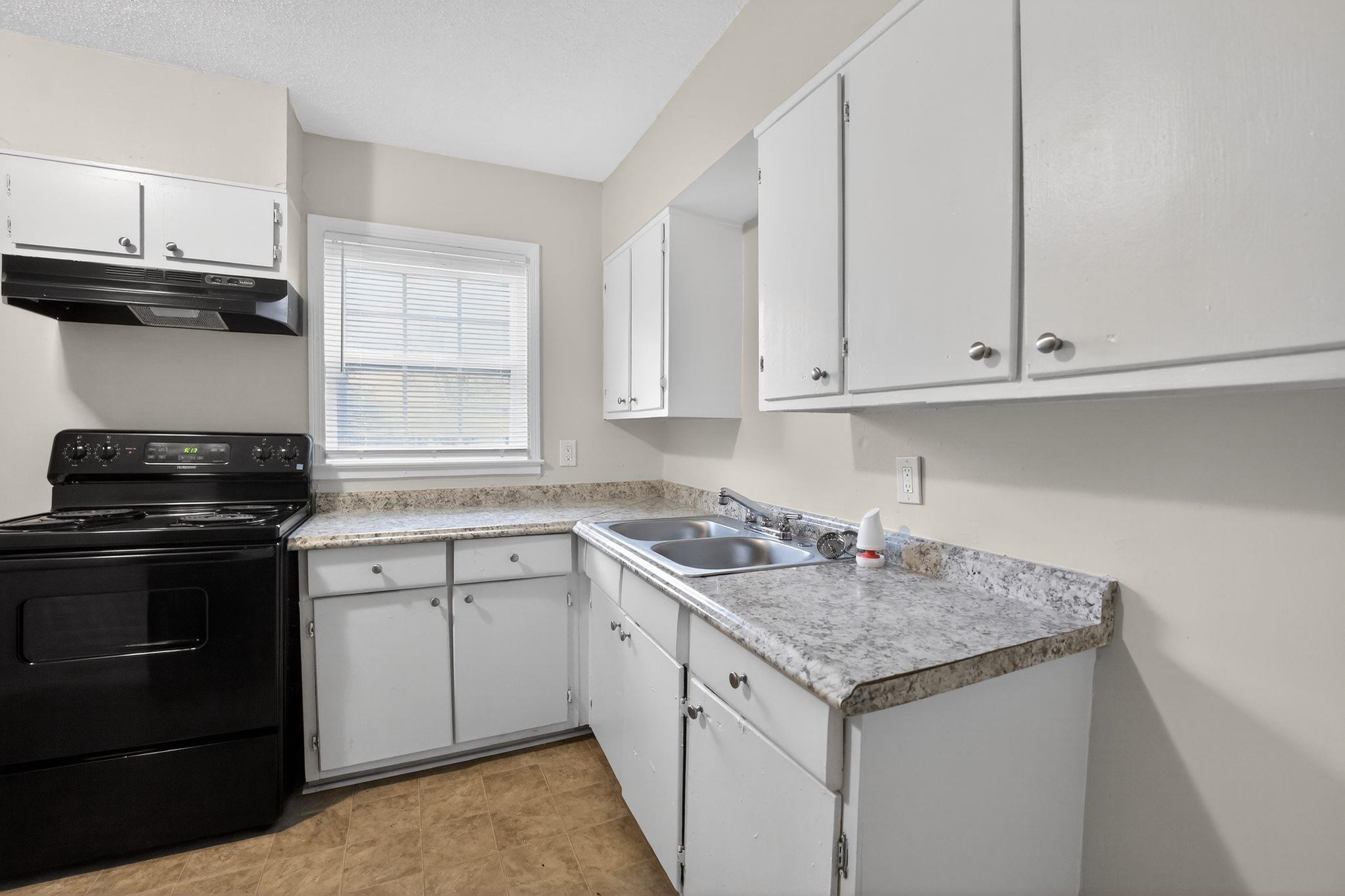 4689 Raleigh Lagrange Road Memphis, TN 38128 - Photo 6 of 30 Kitchen with black electric range, white cabinets, under cabinet range hood, and light countertops