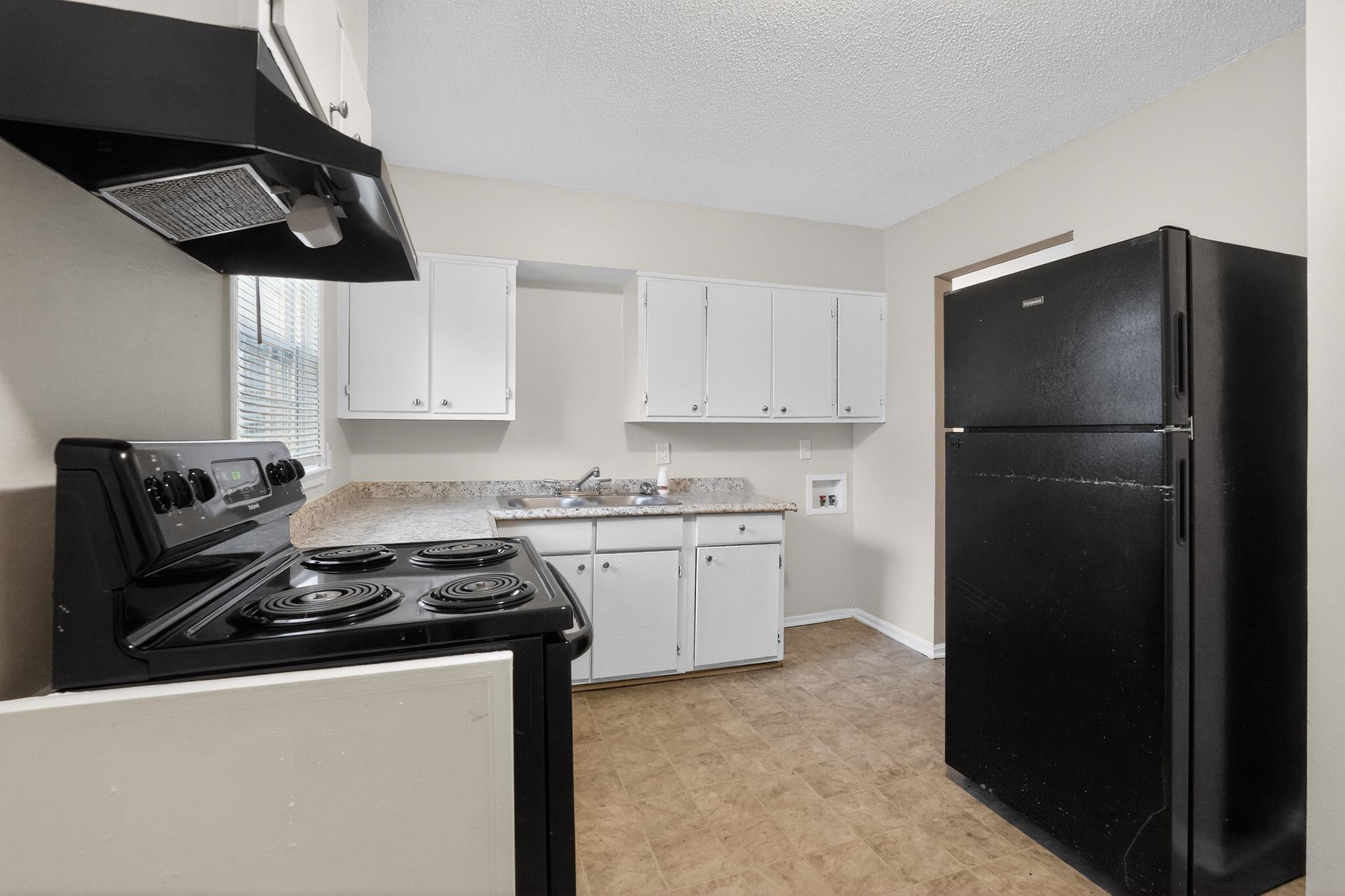 4689 Raleigh Lagrange Road Memphis, TN 38128 - Photo 7 of 30 Kitchen featuring black appliances, white cabinets, under cabinet range hood, light countertops, and a textured ceiling