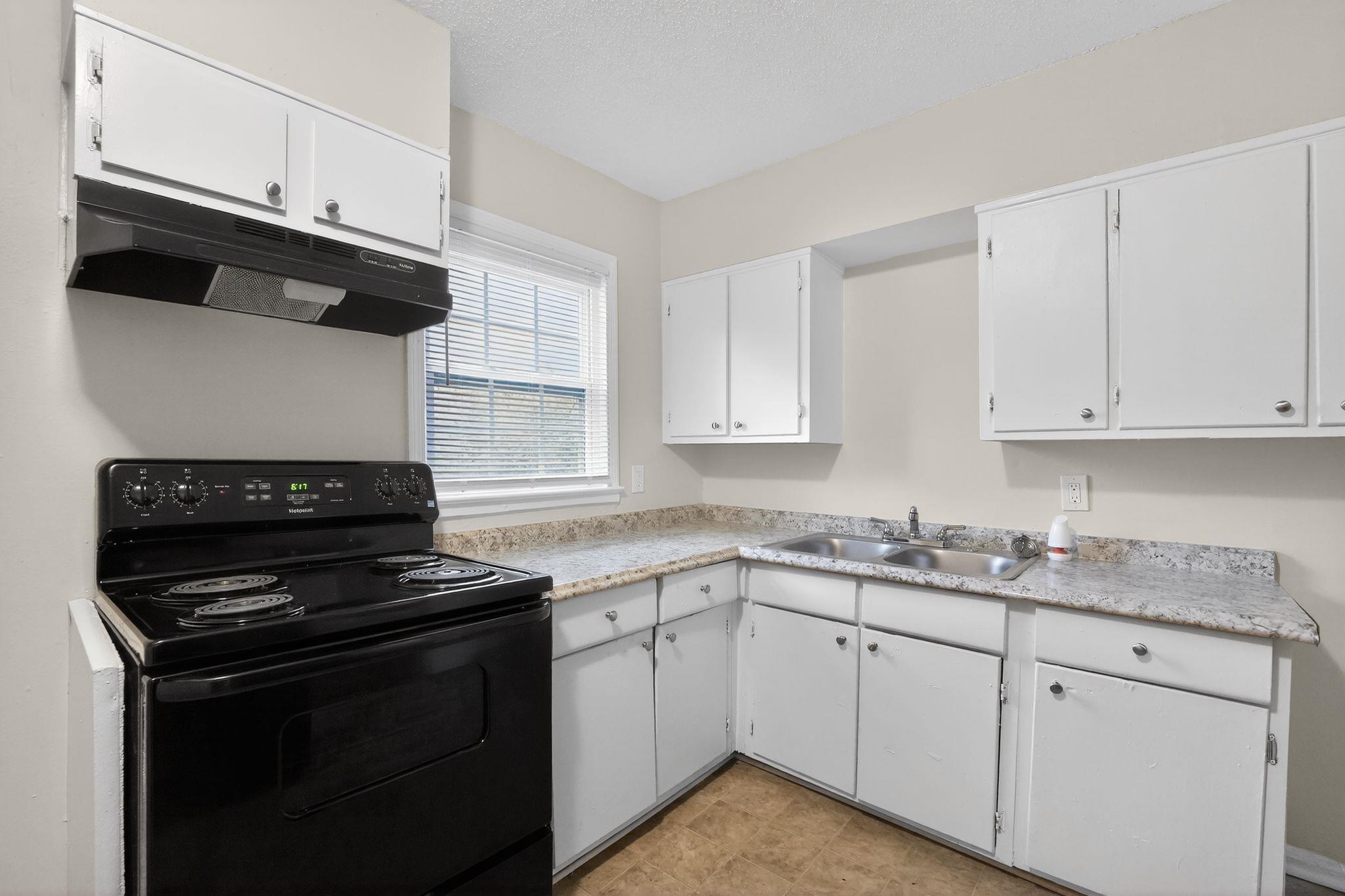 4689 Raleigh Lagrange Road Memphis, TN 38128 - Photo 9 of 30 Kitchen featuring black range with electric cooktop, white cabinets, extractor fan, light countertops, and a textured ceiling
