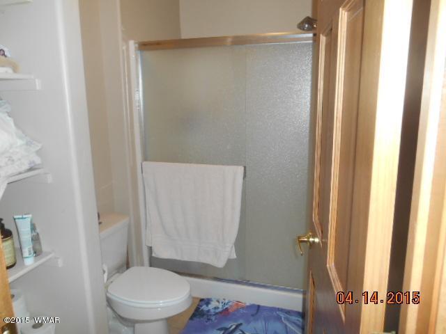 4890 West Cottage Loop Show Low, AZ 85901 - Photo 18 of 28 a white toilet sitting next to a shower