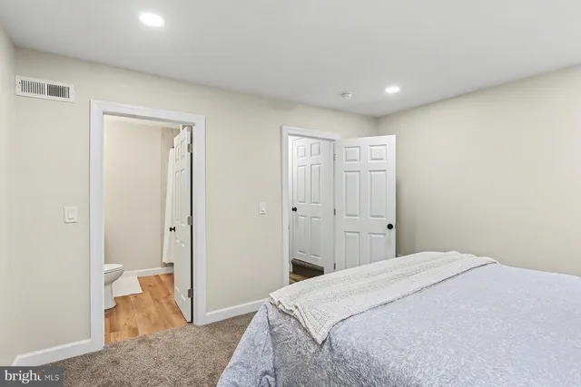 a spacious bedroom with a bed and a view of bathroom