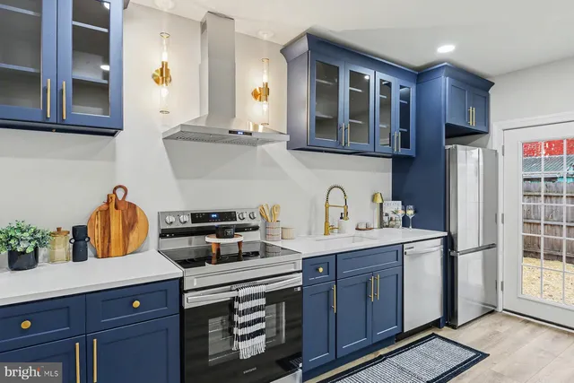 a kitchen with stainless steel appliances granite countertop a refrigerator and a stove top oven
