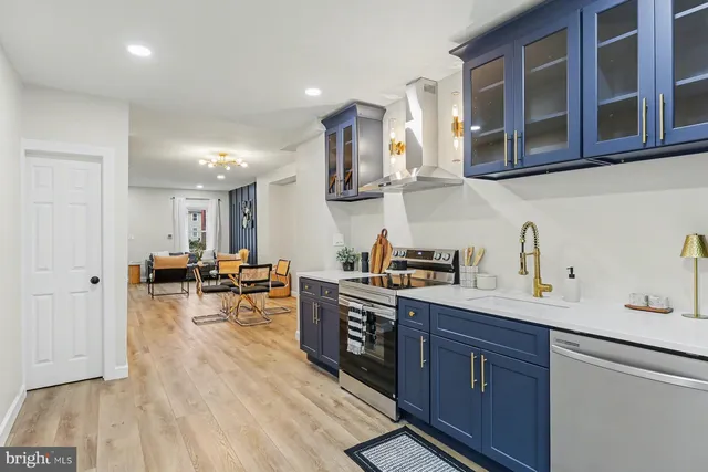 a kitchen with stainless steel appliances granite countertop a sink dishwasher stove and cabinets with wooden floor