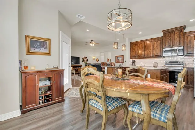 a kitchen with stainless steel appliances granite countertop refrigerator a sink a stove top oven a counter space and cabinets