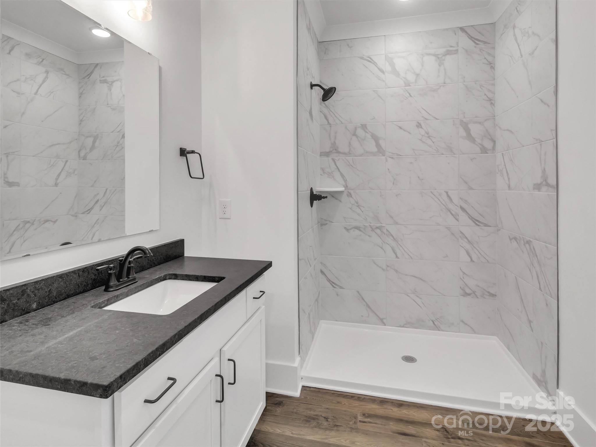 12 Whitson Road Asheville, NC 28805 - Photo 11 of 18 a bathroom with a granite countertop sink a mirror and shower